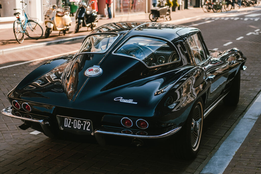 Čierny oldtimer pri chodníku — celý dizajn